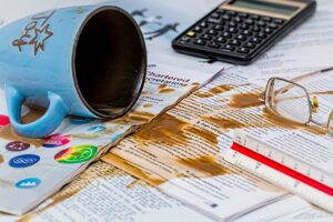 a coffee mug and glasses on papers - success