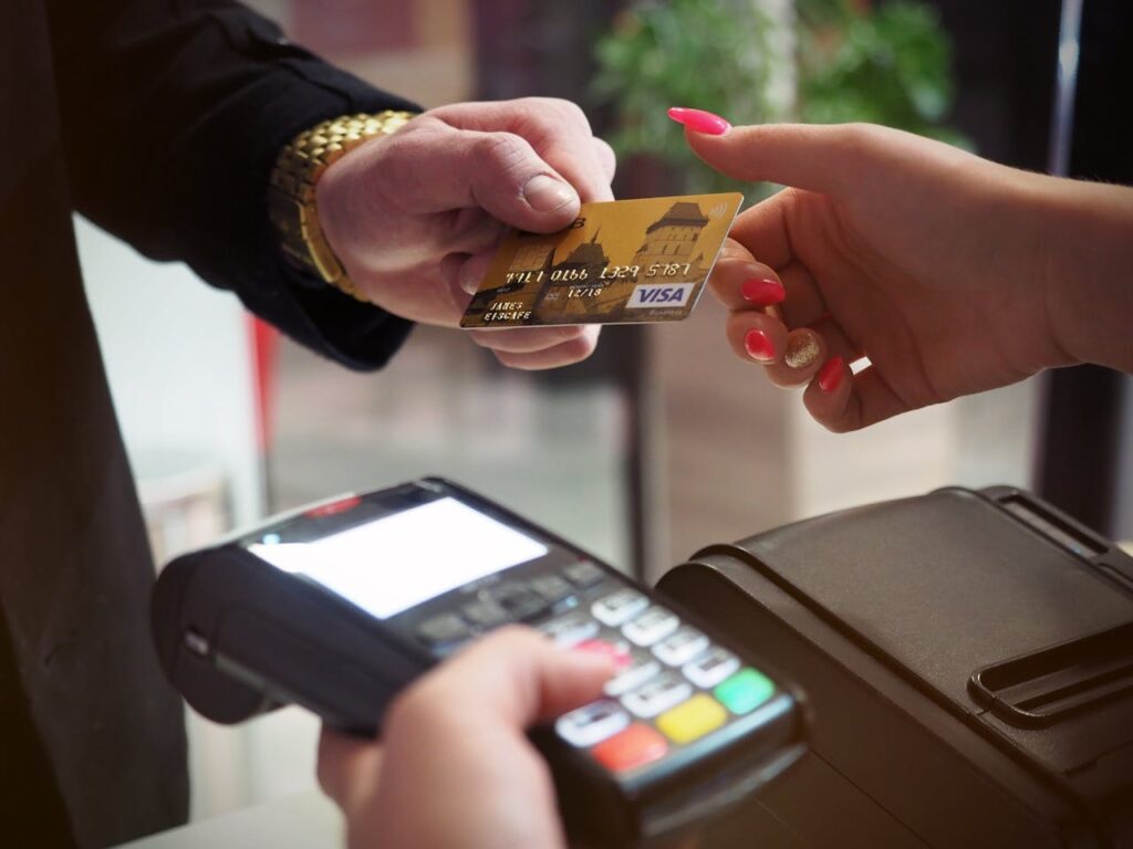 A person paying money by pos machine to wealth